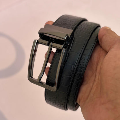 Black belt with a shiny buckle held by a hand on a light background